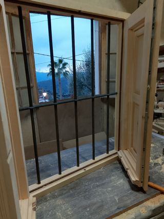 Ventana de madera con reja carcelera 