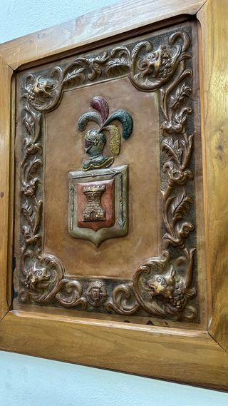 Escudo heráldico sobre cuero repujado y pintado.