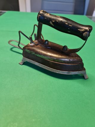 Antigua plancha eléctrica con soporte.