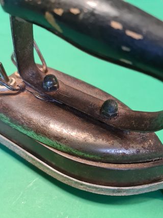 Antigua plancha eléctrica con soporte.