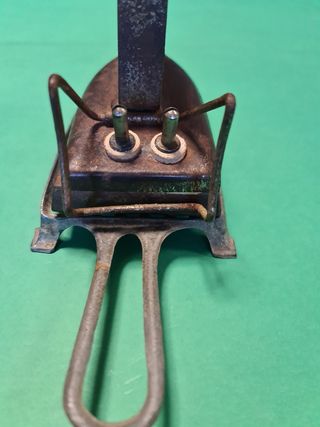 Antigua plancha eléctrica con soporte.