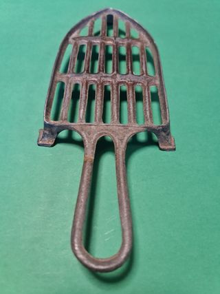 Antigua plancha eléctrica con soporte.