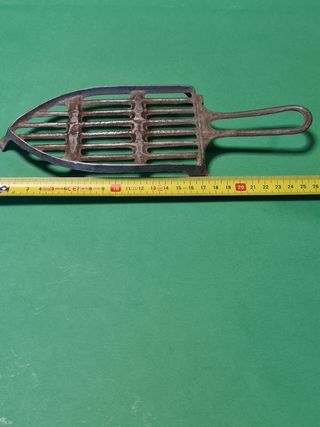 Antigua plancha eléctrica con soporte.