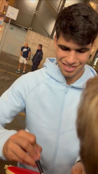 Autógrafo de Carlos Alcara en polo rojo con prueba