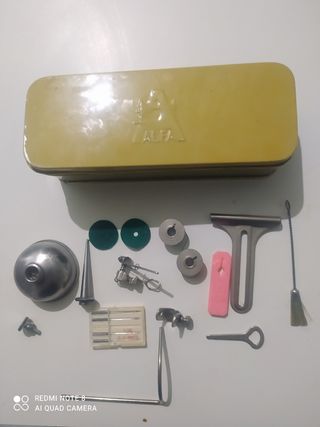 Caja metálica con accesorios de maquina de coser
