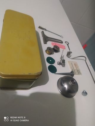 Caja metálica con accesorios de maquina de coser