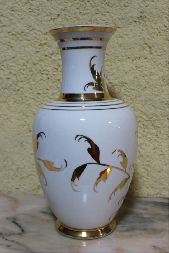 Jarrón de porcelana con flores doradas.