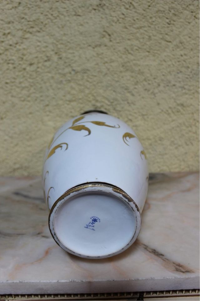 Jarrón de porcelana con flores doradas.