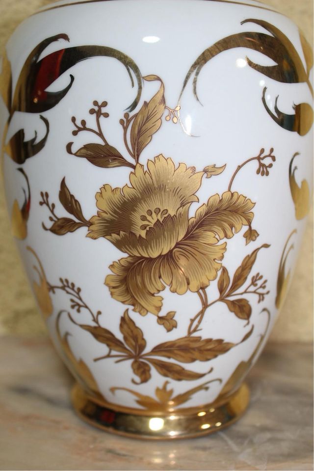 Jarrón de porcelana con flores doradas.