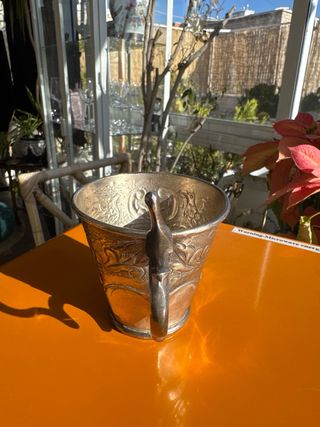 Copa antigua de plata labrada con asa decorativa
