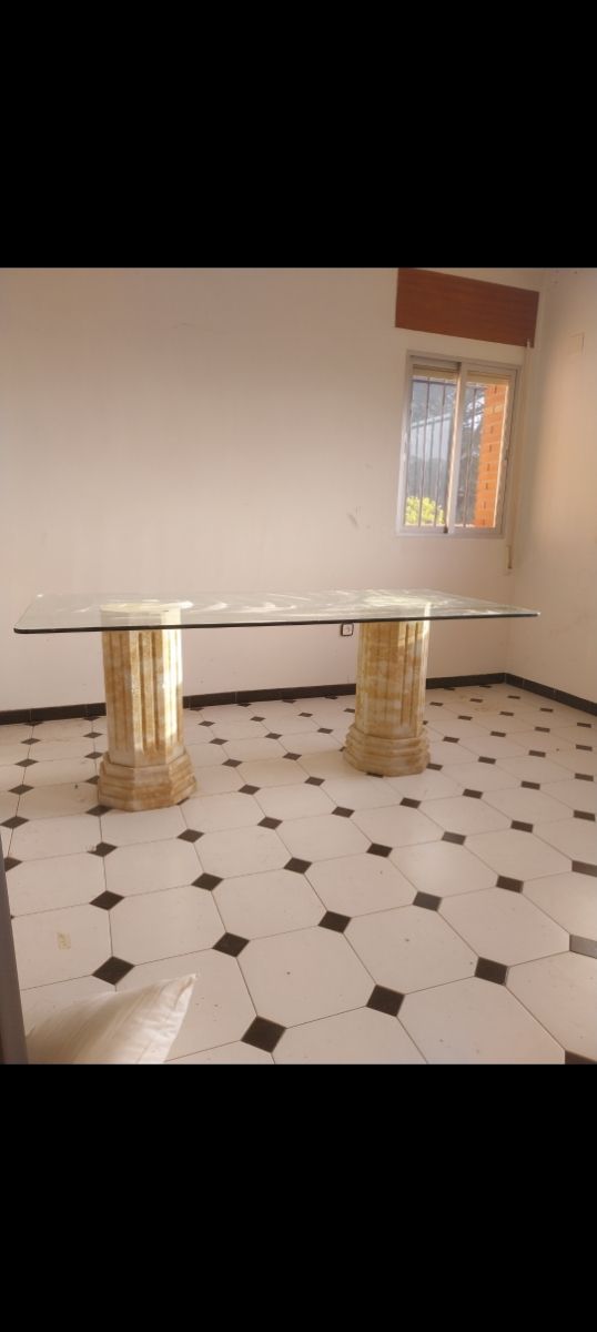 Mesa de cristal con patas de piedra