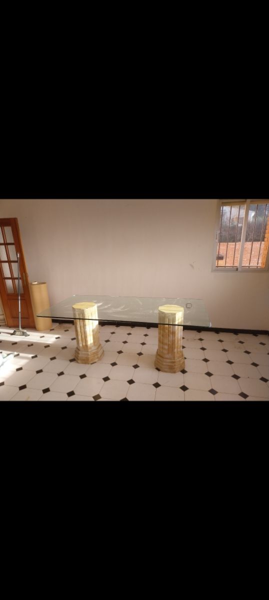 Mesa de cristal con patas de piedra