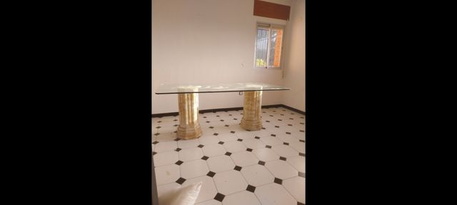 Mesa de cristal con patas de piedra