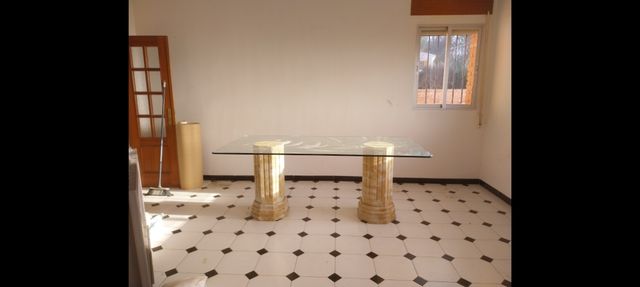 Mesa de cristal con patas de piedra