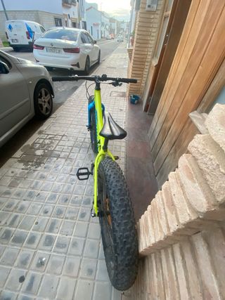 Bicicleta amarilla/verdosa y azul de ruedas gordas