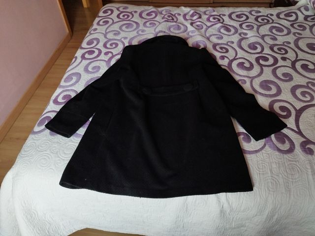 Abrigo negro de mujer abotonado.