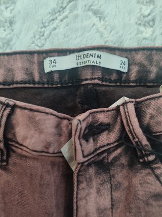 Pantalón vaquero color vino claro.