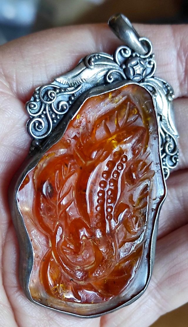 Pendente in ambra scolpita con argento