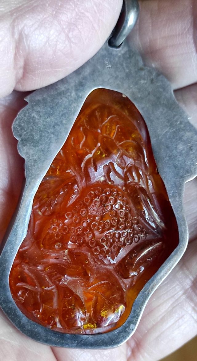 Pendente in ambra scolpita con argento