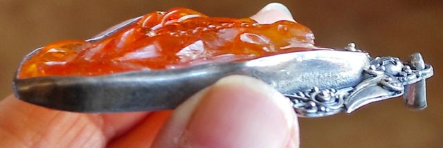 Pendente in ambra scolpita con argento