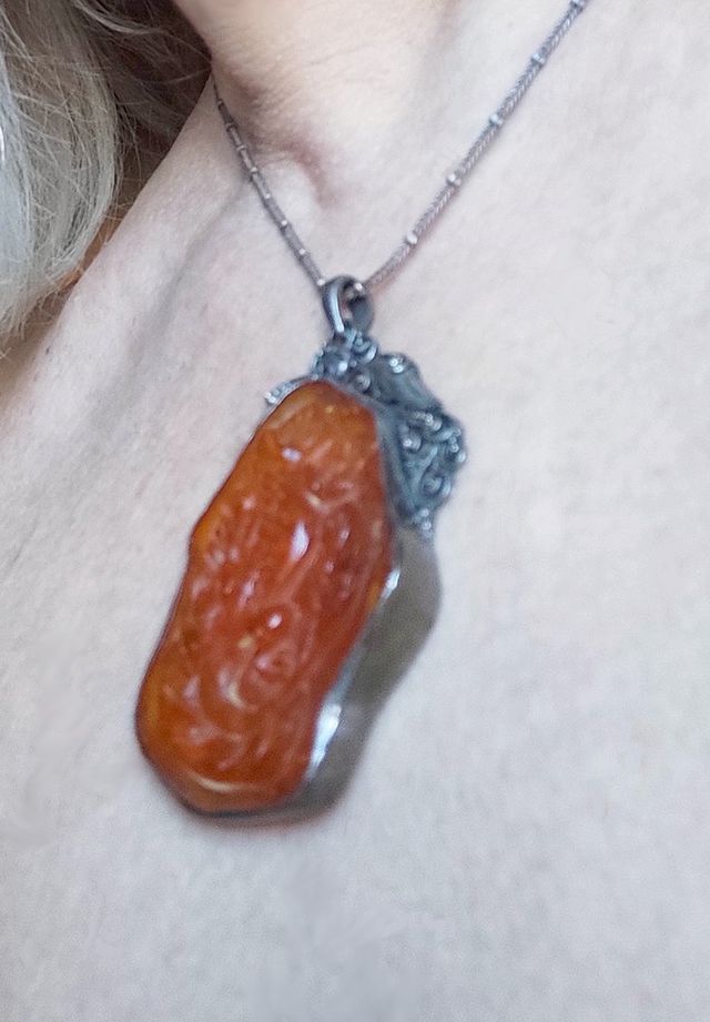 Pendente in ambra scolpita con argento