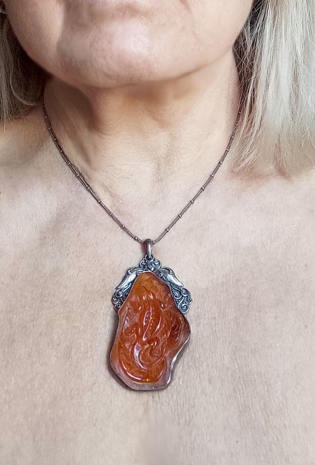 Pendente in ambra scolpita con argento