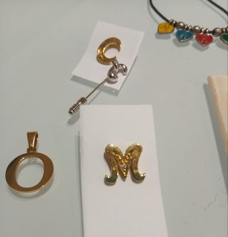 Colgante letra O y pins iniciales