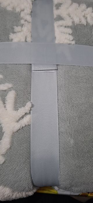 Plaid con decori natalizi su fondo grig