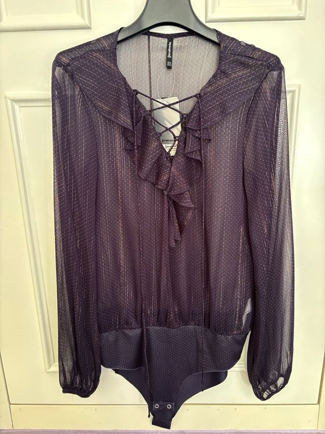 Top Stradivarius tipo body morado con brillos