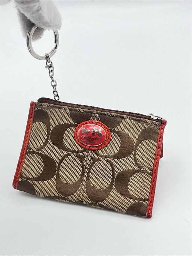 Portamonete Coach marrone in tessuto e in pelle