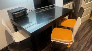 Mesa y 2 sillas (una blanca otra negra)