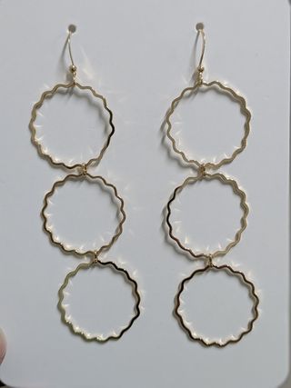 Pendientes dorados en forma de flor.