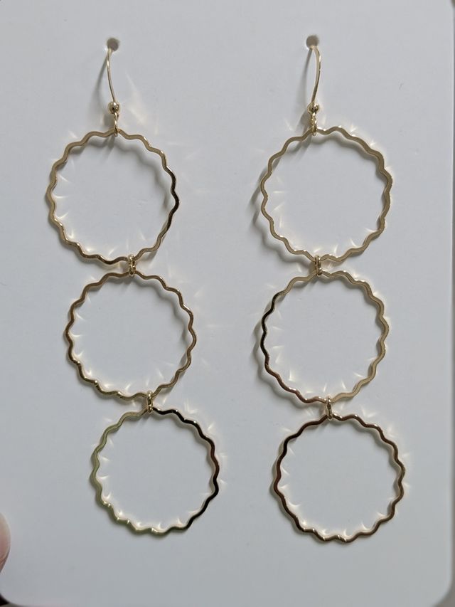 Pendientes dorados en forma de flor.