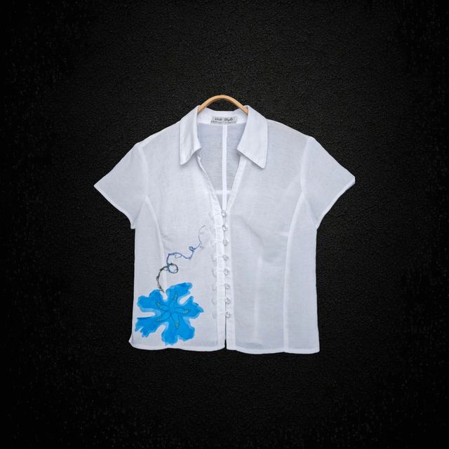 Blusa blanca con adorno en forma de flor