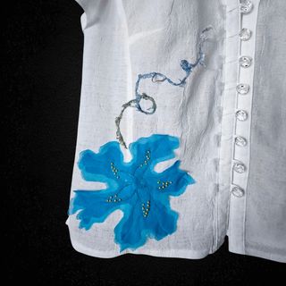 Blusa blanca con adorno en forma de flor
