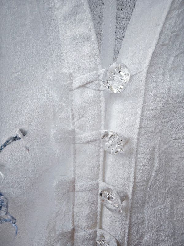 Blusa blanca con adorno en forma de flor