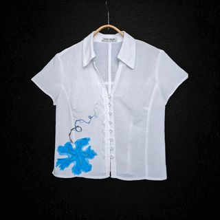 Blusa blanca con adorno en forma de flor