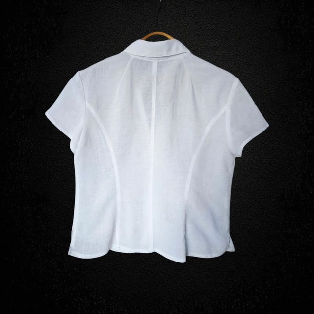 Blusa blanca con adorno en forma de flor