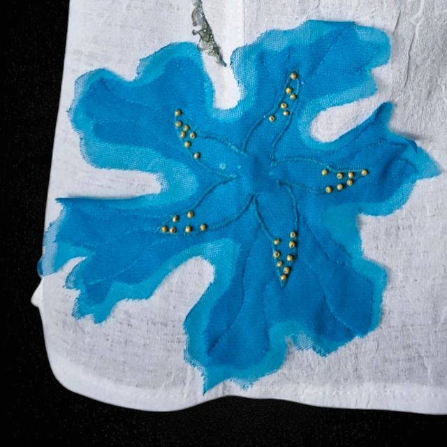 Blusa blanca con adorno en forma de flor