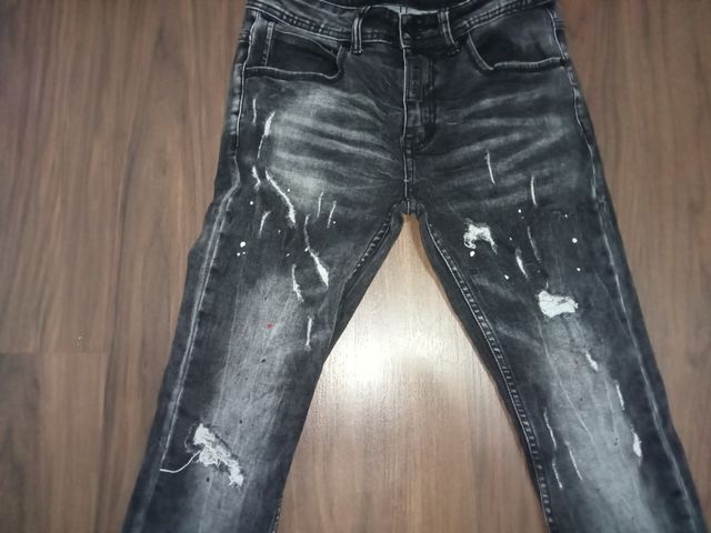 Pantalón vaquero con rotos y manchas