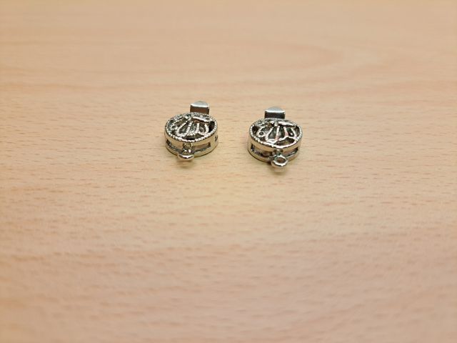 2 chiusure a scatto filigranate con farfalla