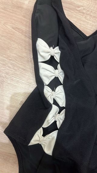 costume nero con fiocchi bianchi laterali