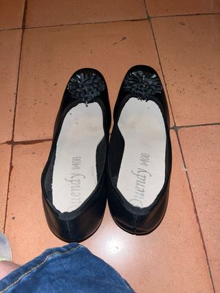Zapatos negros con pompón en la punta