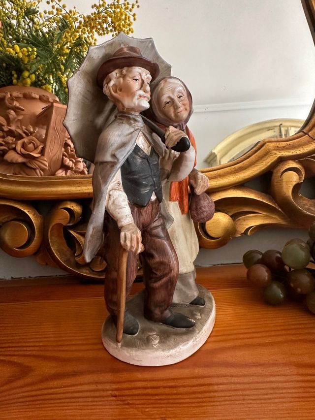 Figura de porcelana   ancianos bajo el paraguas