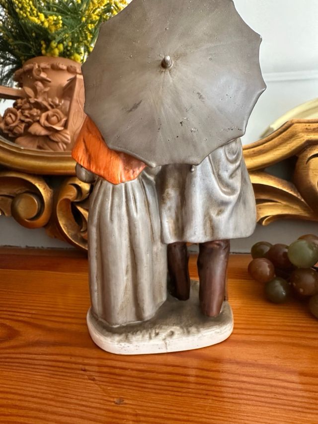 Figura de porcelana   ancianos bajo el paraguas