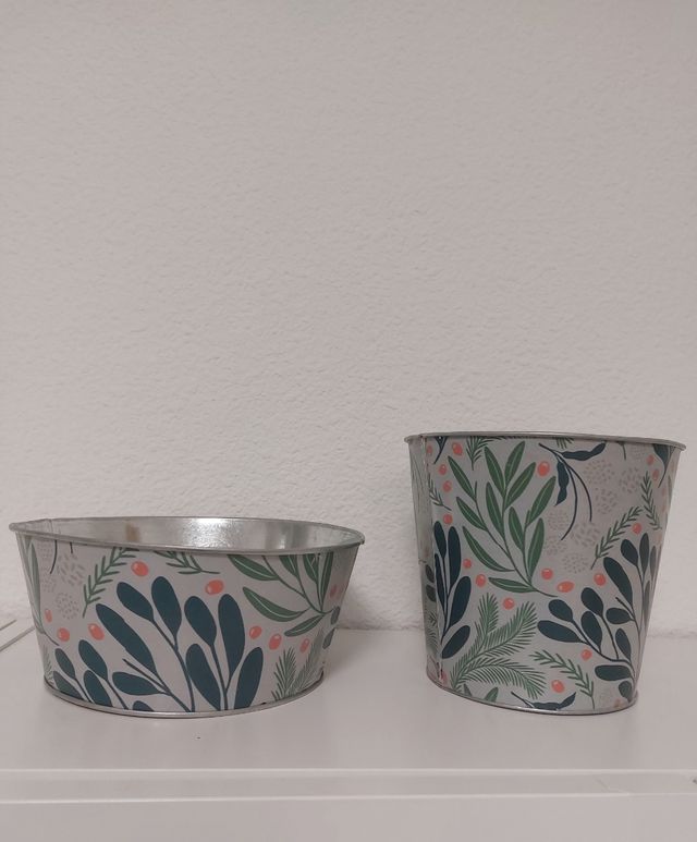 Dos maceteros decorados metálicos.