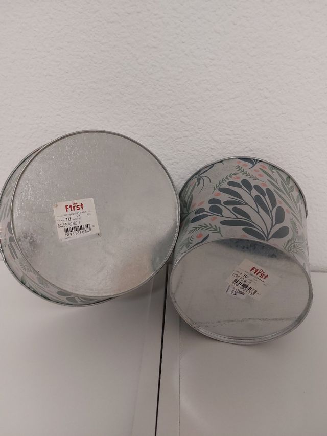 Dos maceteros decorados metálicos.