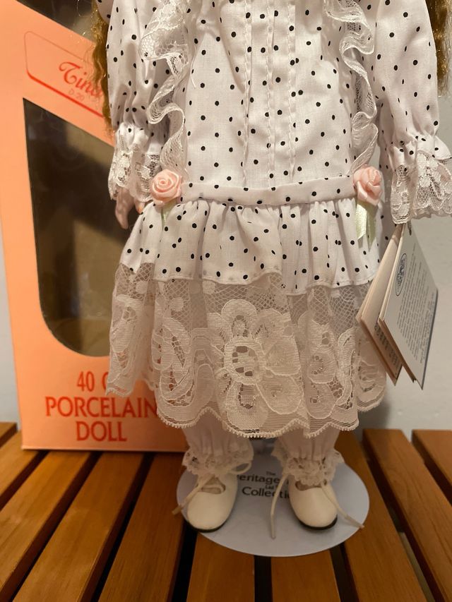 Boneca em porcelana coleção Tina com apoio.