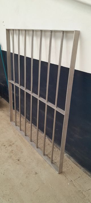 Ventana de aluminlo con persiana y reja de acero 