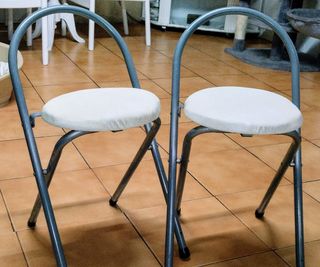 Dos taburete plegables el asiento polipiel blanco
